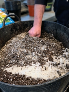 And then mixes in a couple scoops of sand to improve drainage even more and enhance aeration. Sand also prevents soil compaction in the pots.