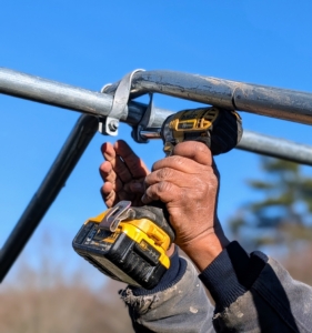 Pete fastens one pair of purlins to the bow section at the center peak.