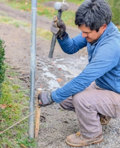 And then small pieces of wood are pounded into the ground next to each steel ground stake. These short wooden pieces provide points at which the burlap can be secured.