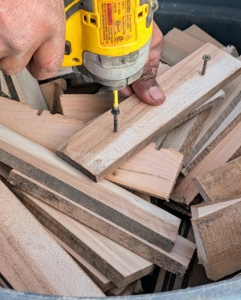 Scraps of wood can be repurposed for various projects. Here, Pete cut small strips from unused wooden pieces. The strips are about six inches long – just long enough to accommodate two screws that will keep the burlap secure. Pete secures crews into the strips to quicken the process.