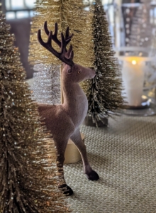 The animals are interspersed between the trees as if they are walking through the woodland in winter.