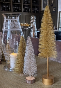 Gold, silver, and copper bottlebrush trees adorn the long dining table in this room.