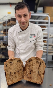 Chef Pierluigi opens this fresh and perfect chocolate chip panettone to show its wonderful pillowy center.