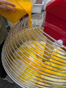 During the busy holiday season, Chef starts making the doughs very early in the morning before sunrise. The dough is made with soft flour, European butter with at least 82% fat, water, organic eggs, sugar, fresh vanilla beans from Madagascar, and the selected flavor ingredients. Here, he is pouring in the egg yolks.