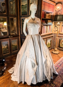 Full skirts, cinched waists, and shapely bodices were characteristic of evening gowns in the 1950s. This gown shimmers in silvery gray satin.