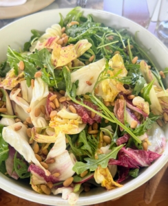 The fresh arugula salad was served with pine nuts and a light vinaigrette.