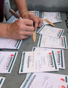 Ryan writes the vegetable and variety on wooden markers. This helps to keep track of the varieties as they grow.