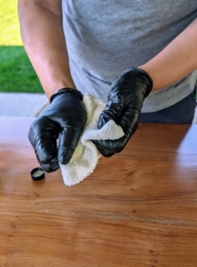 And then rubs the cloth together to spread the oil.