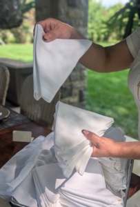 Enma ironed and folded crisp, white napkins for the event.