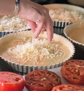 A generous layer of grated Italian Fontina cheese is spread on the chilled crust.