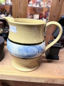This is a 1930s Yellow Ware Pitcher. Yellow Ware is a type of highly-fired earthenware pottery made from a rich yellow clay body with a clear glaze that gives it its distinctive warm golden-yellow color. It was produced in both England and North America and became a popular style of pottery in its time. I have a very large collection of Yellow Ware.