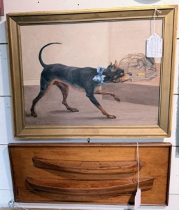 And here is a Folk Art painting of a dog eyeing a rat or mouse in its cage. This is signed by artist A.E. Boulanger, a 19th century painter known for creating small-scale handcrafted works of oil on canvas.