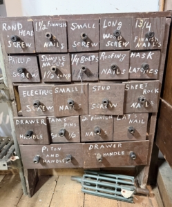 This likely came from an old hardware store. It is a vintage storage unit for screws and nails.