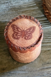 This covered piece was made by the late Butch Philipps, a tribal elder of the Penobscot Nation and talented birchbark artist known for etching winter bark with traditional Penobscot double curve motifs and designs. This container could have been used for storing garden seeds or even tea.