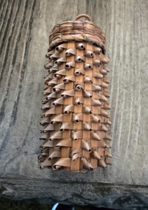 This weaved storage basket could have held drinking glasses or bottles, much like a modern day "koozie" or insulated bottle sleeve.