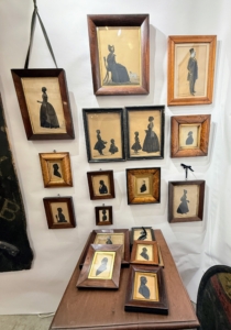 Silhouette prints featured a style of black-and-white profile portraits that originated in the 18th and 19th centuries. These prints were often used as a form of identification or as decorative art in the home. They are typically hand-cut paper profiles, sometimes reverse-painted or framed in ornate wood, and often depicted individuals, couples, or scenes.