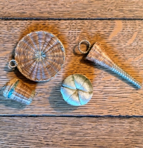 I especially liked these weaved sewing kits. The larger round sweetgrass piece is a needle case. There is also a pin cushion, thimble holder, and the longer piece is a scissor case.