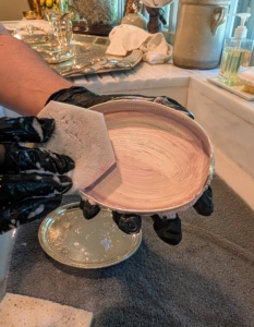 Enma rubs both sides of the dish, thoroughly spreading the cream on every surface of the piece. Tarnish ranges in color from a light yellowy gold to almost black, depending on how long it has been allowed to develop. In addition to using soft sponges and rags, use cotton swabs to apply the cream to tight spots and crevices when cleaning.