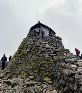Silas realized that he was the highest person in the UK when he was atop this emergency shelter at the summit.