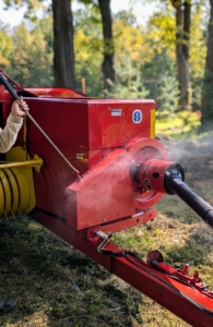Chhiring cleans every crevice of the baler to remove any debris caught in the machine. This is also a good time for Chhiring to check any parts that may need more maintenance attention. A baler is a piece of farm machinery used to compress a cut and raked crop into compact bales that are easy to handle, transport, and store.