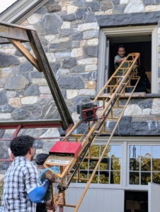 To get the bales up into the hayloft of my stable, a long motorized bale conveyor, or hay elevator, is set up from the wagon to the window of the loft.