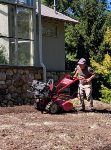 The machine is set to till the soil at about six to eight inches deep. It is not a heavy piece of equipment, but does need to be pushed slowly through the soil to work it well.