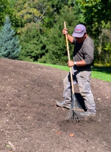 Phurba goes over the entire space with a long hard rake to level the bed.