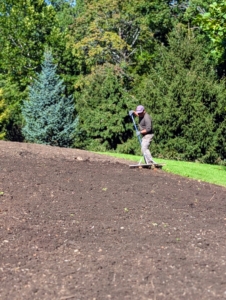 Then he uses a hard rake, or bow rake, to break up any soil clumps and spread it evenly.
