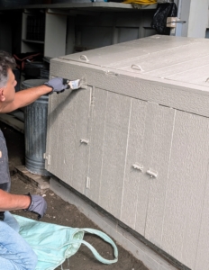 Fernando repaints the bird feed storage station. It's "Bedford Gray," of course.