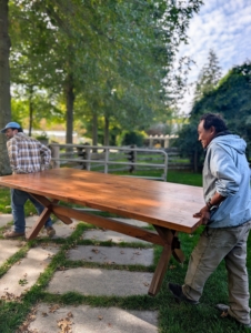 Doing so made it easy to transport when needed. Here, Pete and Jimmy carry each table piece to its designated storage place.
