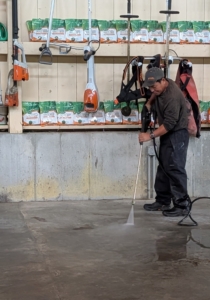 Phurba uses the power washer to clean the cement floors of any mud and other debris.