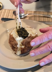 Here I show my guests how I dress the potato - first a dollop of crème fraîche and then a generous spoonful of the finest caviar one can find.