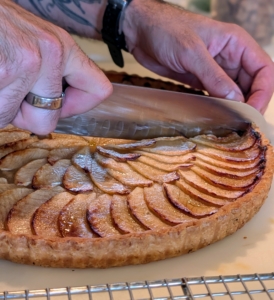 The tart is cut carefully with a very sharp knife, which cuts through the flaky, crisp crust and soft filling without crushing either.
