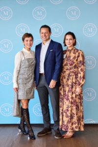 A “step-and-repeat” wall banner was put up in one area for social media photos. Here are Natasha, Heath, and Rachel.(Photo by Arianna Tettamanzi)