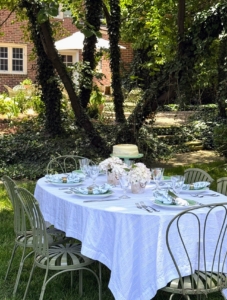 He and Kevin dine al fresco using flowers from the garden as centerpieces, and cakes resting on cake stands.