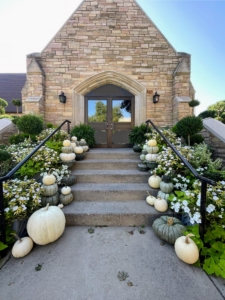 Dennis and Bernie purchased a former church and then lovingly renovated and decorated it to be their home - largely inspired by the Martha Stewart brand. Here, they use a variety of green and white pumpkins, which they grew, as well as coordinating white flowered plants to embellish their front steps.