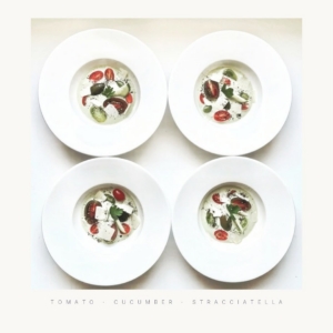 This is tomato, cucumber stracciatella, a dish combining fresh summer produce with stracciatella cheese — a creamy, shredded Italian cheese — often used in salads, pasta dishes, or as a topping.