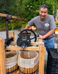 The flywheel is an 18-pound cast iron wheel attached to the grinding shaft. This allows the operator to turn the drum which grinds the apples. It takes quite a few apples to fill the tub. Once the tub is filled with apple pulp – skins, seeds and cores – the pressing process can begin.
