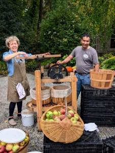 Pati and Carlos are getting some great exercise pressing apples. This “American Harvester” model consists of a hand-crank grinder affixed to a basket press. The grinder, pressing screw, and flywheel crank are all made of durable cast iron.