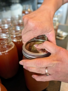 After the cider is poured, the top of the jar is wiped perfectly clean and the lids are screwed on top.