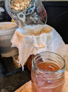 The juice is poured into a strainer and directly into a jar.