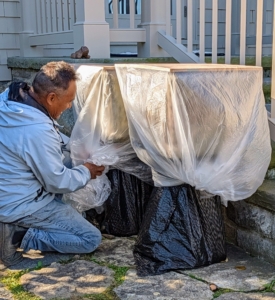 Here, Pete tucks in and secures the plastic, so every part of the urns are covered.