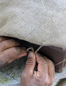 Here, Pete secures the end of the jute twine and makes a knot.