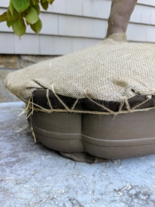 Because this pot does not have feet, Pete ties jute twine around the vessel, so supporting pieces of twine can be secured.