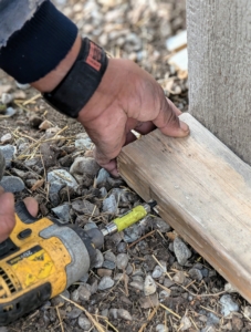 Pete secures a piece of 2x4 wood which will provide a base for the sliding doors.
